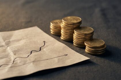 Stacked gold coins beside a rising chart